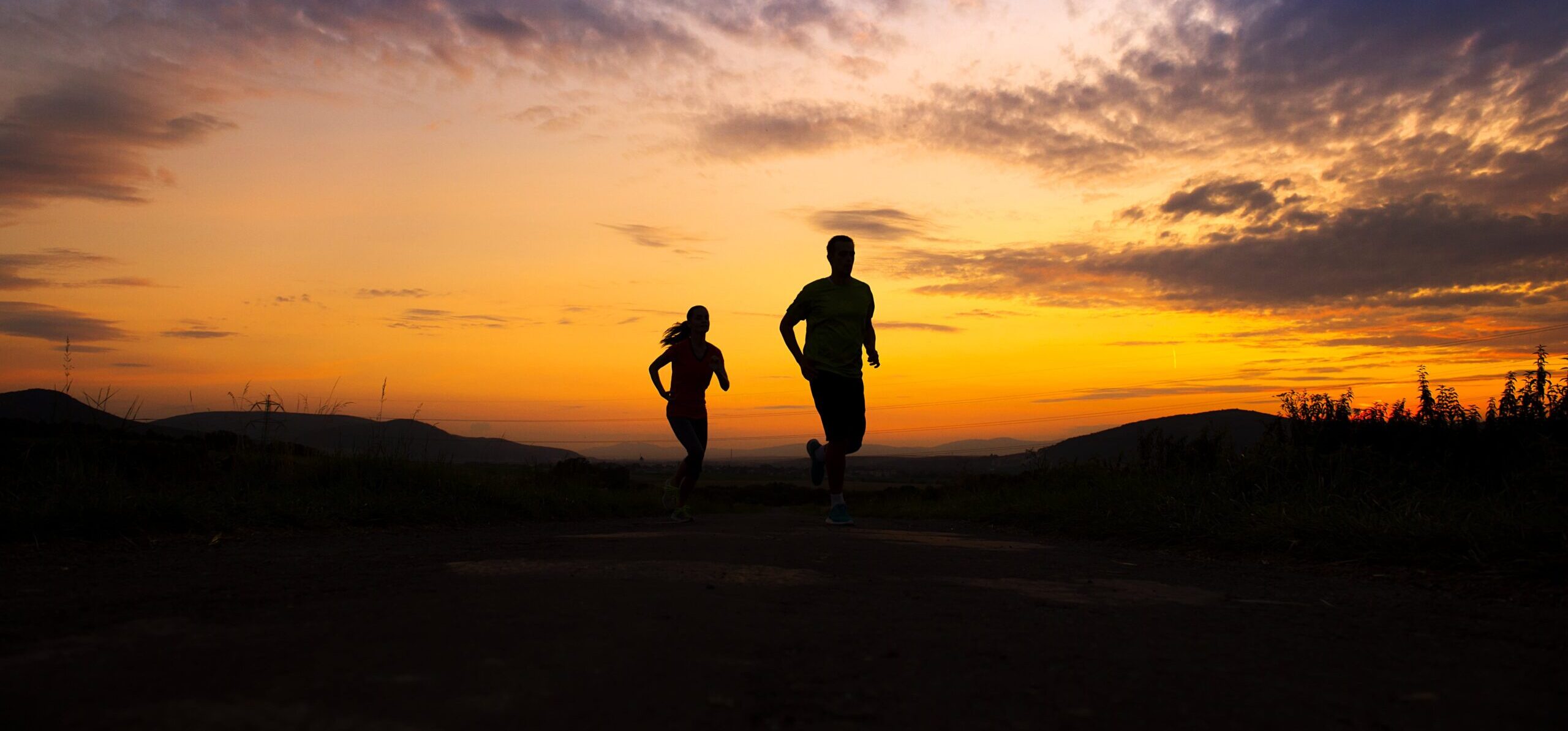 silhouette of couple running at sunset representing support and sponsorship